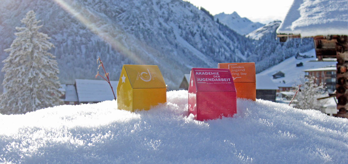 drei Teelicht-Häuschen im Schnee